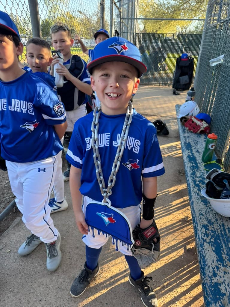 Young Blue Jays baseball player wearing his custom drip-cap hype chain